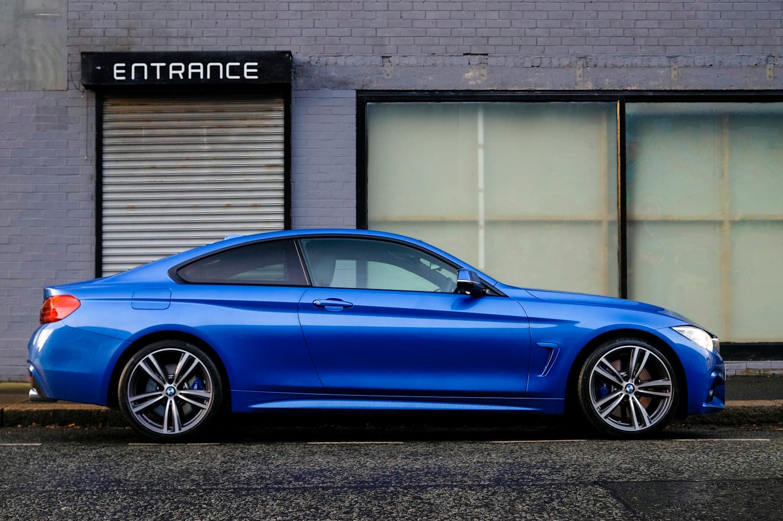 Blue sedan parked on a city street, viewed side-on